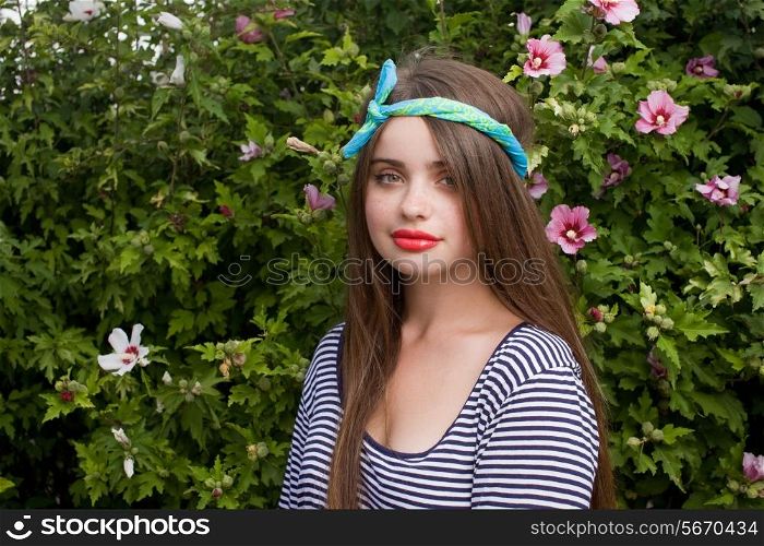 trendy teenager model with kerchief posing on flowers BG