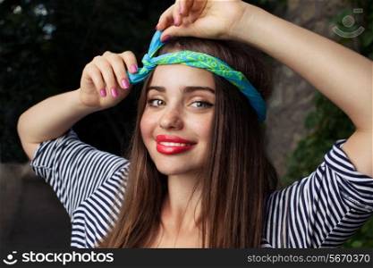 trendy teenager model with kerchief posing with flowers. Outdoor