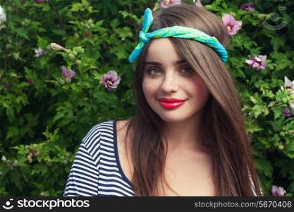 trendy teenager model with kerchief posing with flowers. Outdoor