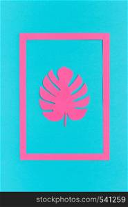 Trendy tropical pink leaf monstera of paper in frame on blue background. Creative Flat lay Top view Greeting card or poster Minimal style.. Trendy tropical pink leaf monstera of paper in frame on blue background. Creative Flat lay Top view Greeting card or poster Minimal style