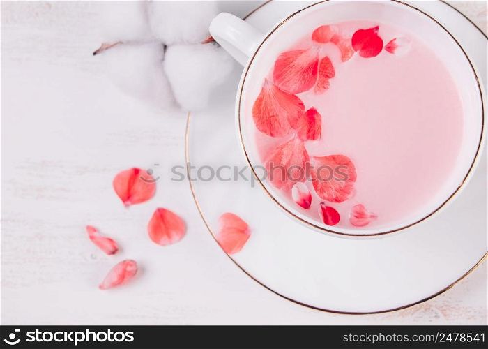 Trendy vegan tea on a white background. Pink matcha with rose petals in a cup. Relaxing drink recipe for sleepy times.. Trendy vegan tea on white background. Pink matcha with rose petals in a cup. Relaxing drink recipe for sleepy times.