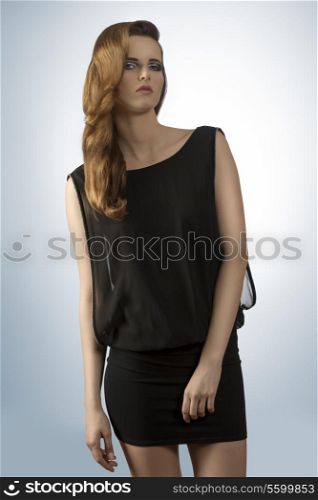 trendy young girl with elegant sexy black dress, stylish make-up and long hair-style. Sensual expression, perfect body
