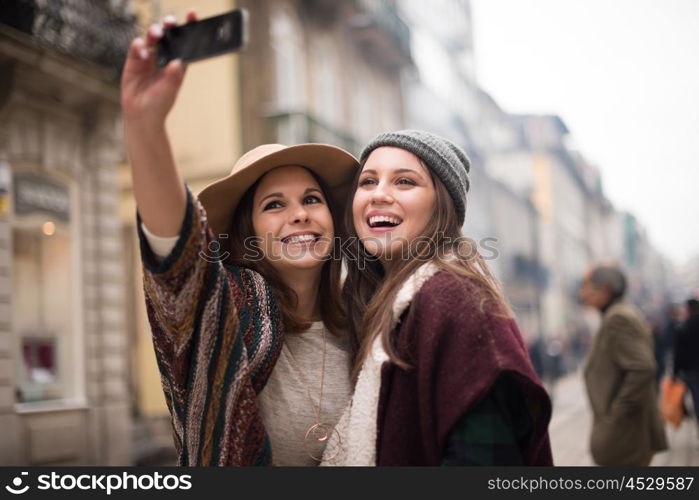 Trendy young women taking selfies in the city