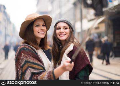 Trendy young women taking selfies in the city