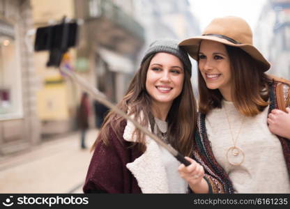 Trendy young women taking selfies in the city