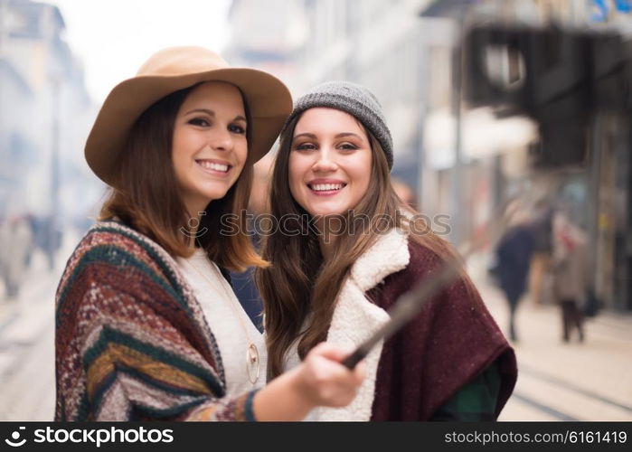 Trendy young women taking selfies in the city