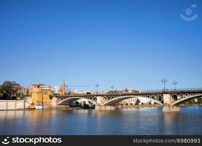 Triana Bridge (Isabel II Bridge) from 19th century on Guadalquivir river in the city of Seville, Andalusia, Spain.