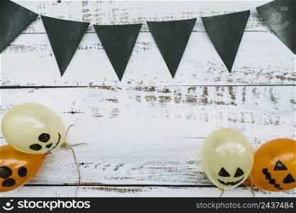triangle dark flags hanging balloons with creepy faces wooden background