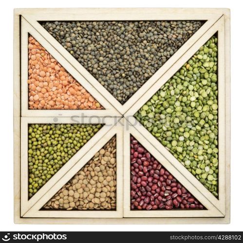 triangles and squares abstract - a variety of beans and lentils in an isolated wooden tray