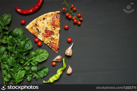 triangular piece of baked pizza with mushrooms, smoked sausages, tomatoes and cheese, black background, flat lay, copy space