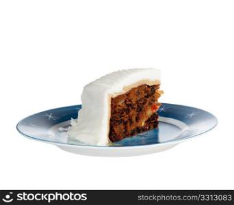 Triangular slice of traditional christmas cake on a blue starry plate