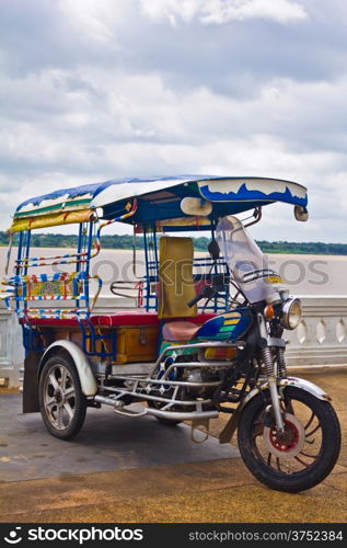 Tricycle in Thailand with Mae Khong River.