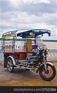 Tricycle in Thailand with Mae Khong River.