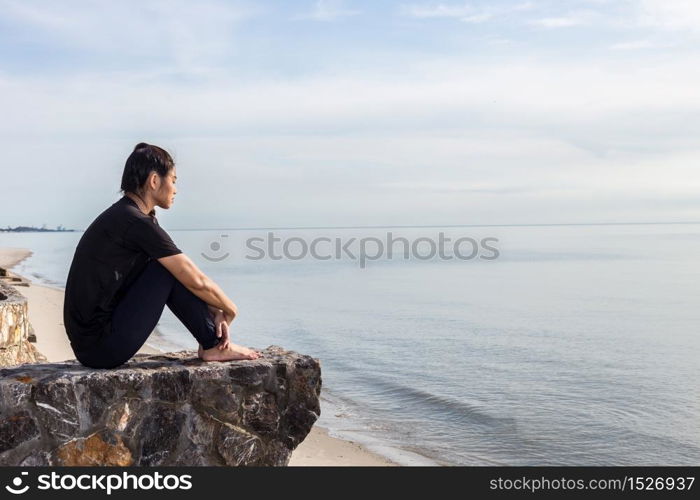 Tried and stressed woman sitting on the beach