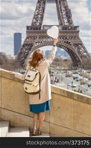 trip across Europe. girl with a balloon in the shape of a hearton the background of the Eiffel Tower in Paris. France