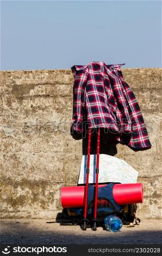 Trip travel relax survival concept. Plaid shirt with hiking gear. Outdoor equipment with bagpack on wall.. Plaid shirt with hiking gear.