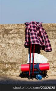 Trip travel relax survival concept. Plaid shirt with hiking gear. Outdoor equipment with bagpack on wall.. Plaid shirt with hiking gear.
