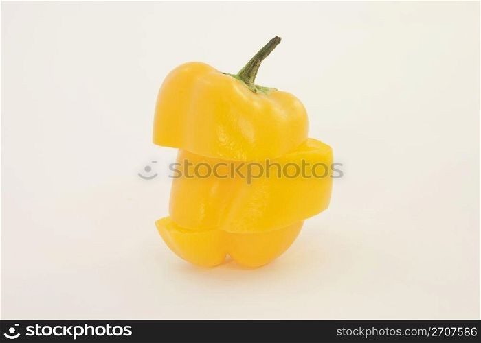 Triple sliced pepper is reconstructed in a different strategy while remaining upright and balanced on a white background