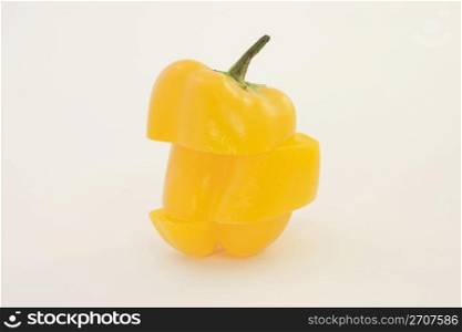 Triple sliced pepper is reconstructed in a different strategy while remaining upright and balanced on a white background