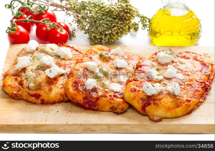 tris of mixed pizza on wood with ingredients