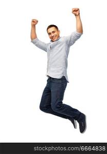 triumph, power and people concept - happy young man jumping over white background. happy young man jumping over white background