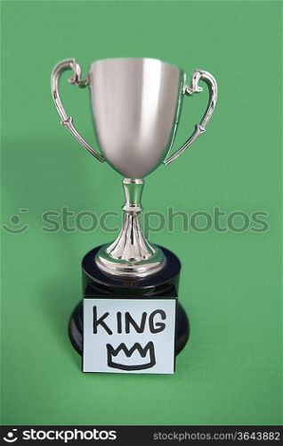 Trophy with sticky note over colored background