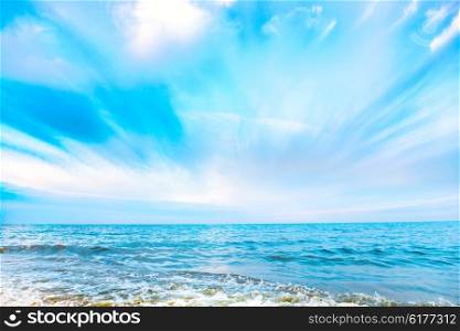 Tropical beach and blue sea with waves, white clouds on background
