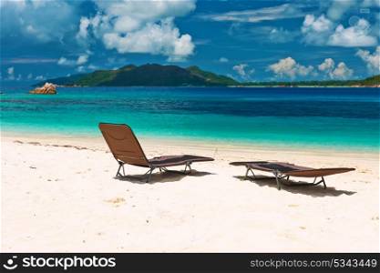 Tropical beach at Seychelles with chaise lounge