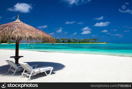 tropical beach in Maldives with few palm trees and blue lagoon