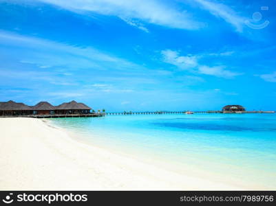 tropical beach in Maldives with few palm trees and blue lagoon