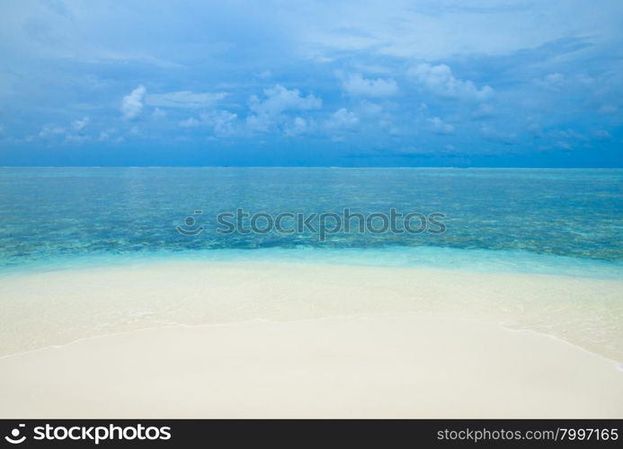 tropical beach in Maldives with few palm trees and blue lagoon