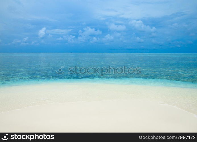 tropical beach in Maldives with few palm trees and blue lagoon