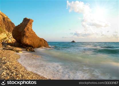 Tropical beach on the sunset with water and rocks.