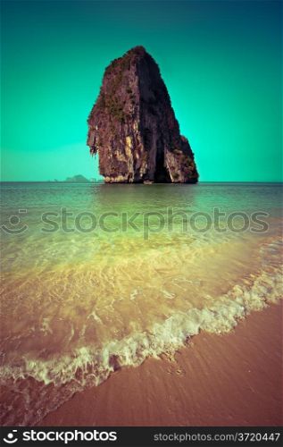 Tropical beach view in vintage style. Ocean landscape with rock formation island at Pranang cave beach, Railay, Krabi, Thailand