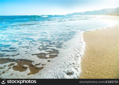 Tropical beach with sand and sea wave at background