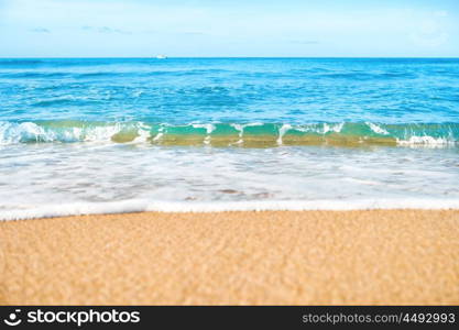 Tropical beach with sand and sea wave at background