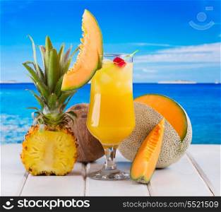 tropical cocktail with fresh fruits on a beach