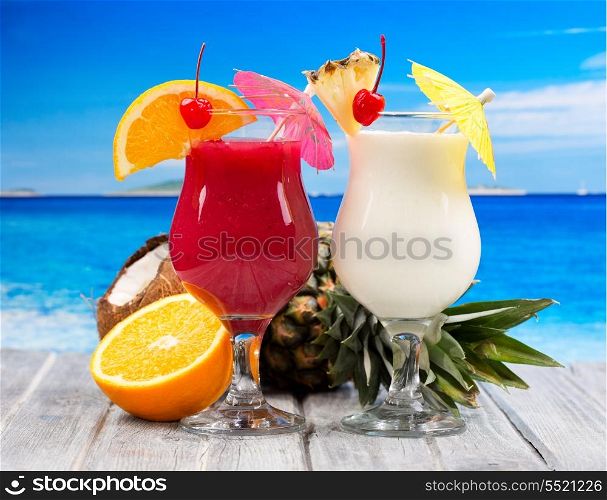 tropical cocktails with fresh fruits on a beach
