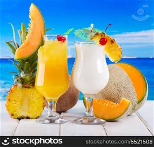 tropical cocktails with fresh fruits on a beach