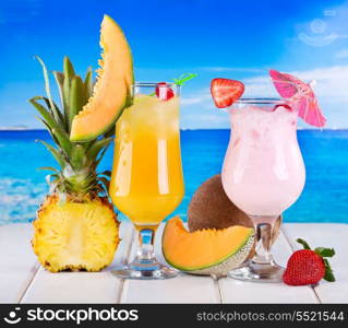 tropical cocktails with fresh fruits on a beach