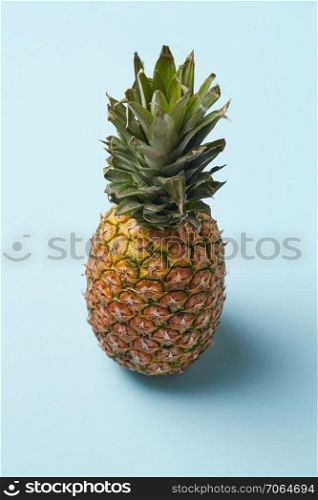Tropical fresh pineapple whole fruit on blue background. Top view. Summer concept.. single whole pineapple isolated on blue background