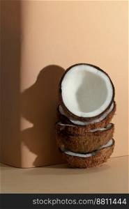 Tropical fruit concept, Fresh coconut halves stacked on cream color background.