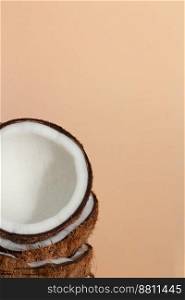 Tropical fruit concept, Fresh coconut halves stacked on cream color background.