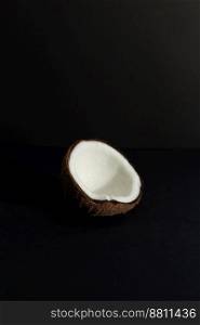 Tropical fruit concept, Halves of fresh white coconut on black background.