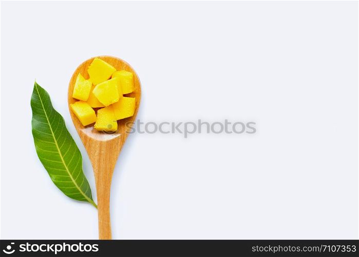 Tropical fruit, Mango cube slices and leaf with wooden spoon on white background. Copy space