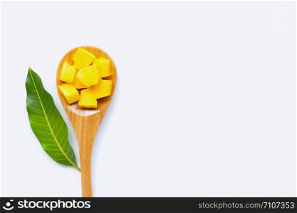 Tropical fruit, Mango cube slices and leaf with wooden spoon on white background. Copy space