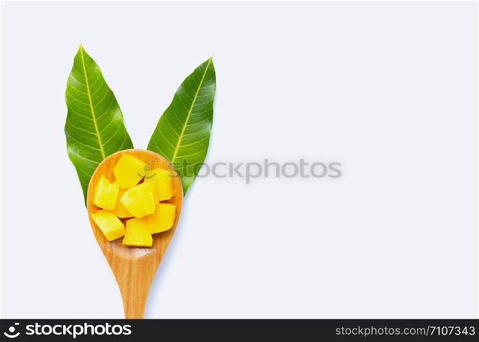 Tropical fruit, Mango cube slices with wooden spoon and leaves on white background. Copy space