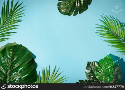 Tropical green palm leaf branches on blue background. flat lay, top view. Tropical green palm leaves