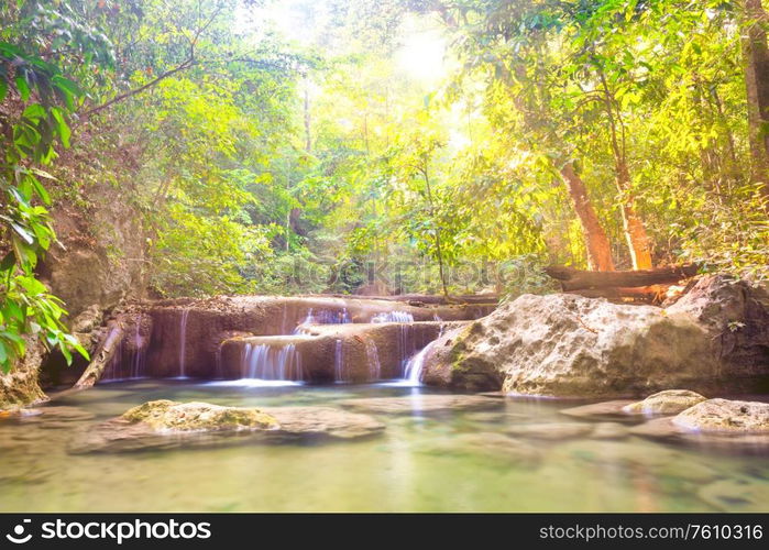 Tropical landscape with beautiful cascades of waterfall and green trees in wild jungle forest. Erawan National park, Kanchanaburi, Thailand