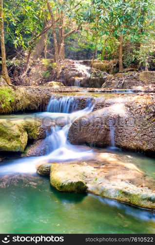 Tropical landscape with beautiful cascades of waterfall and green trees in wild jungle forest. Erawan National park, Kanchanaburi, Thailand